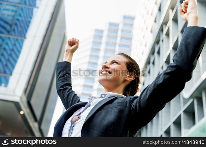 Portrait of business woman smiling outdoor. Portrait of young business woman outdoors with arms raised up