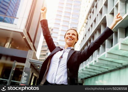 Portrait of business woman smiling outdoor. Portrait of young business woman outdoors with arms raised up