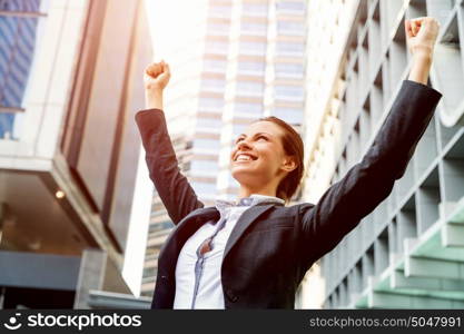 Portrait of business woman smiling outdoor. Portrait of young business woman outdoors with arms raised up