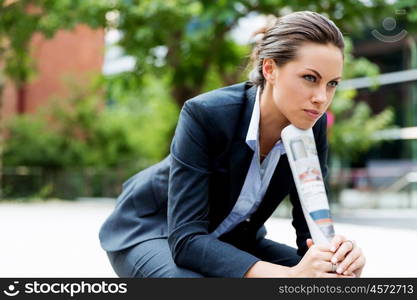 Portrait of business woman smiling outdoor. Portrait of young business woman outdoors sitting and thinking