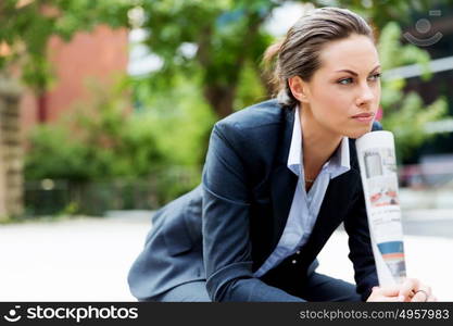 Portrait of business woman smiling outdoor. Portrait of young business woman outdoors sitting and thinking