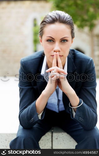 Portrait of business woman smiling outdoor. Portrait of young business woman outdoors sitting and thinking