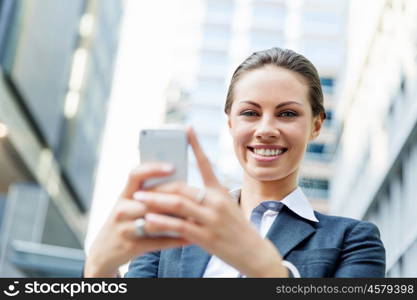 Portrait of business woman smiling outdoor. Portrait of young business woman with mobile phone outdoors