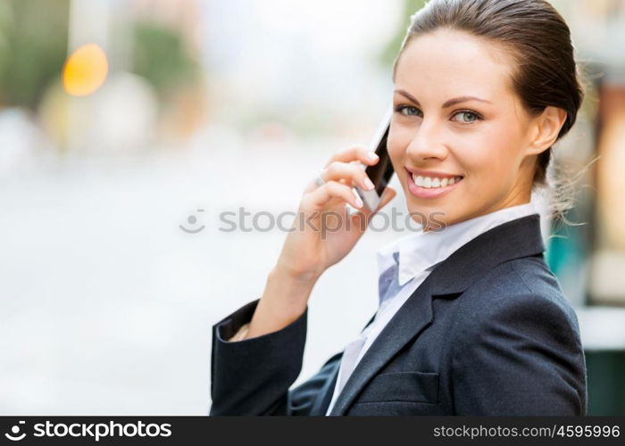 Portrait of business woman smiling outdoor. Portrait of young business woman with mobile phone outdoors