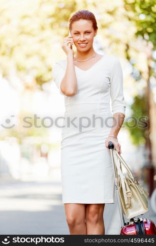 Portrait of business woman smiling outdoor. Portrait of young business woman with mobile phone outdoors