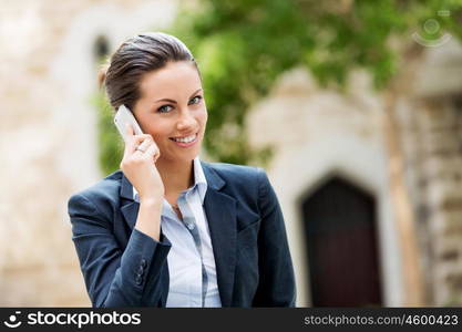 Portrait of business woman smiling outdoor. Portrait of young business woman with mobile phone outdoors