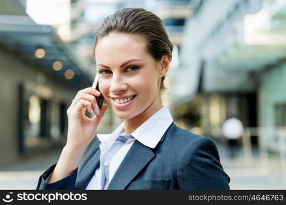 Portrait of business woman smiling outdoor. Portrait of young business woman with mobile phone outdoors