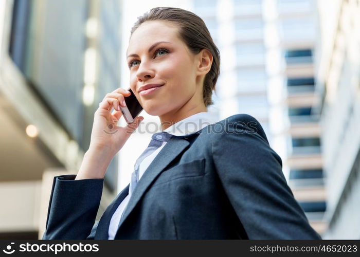 Portrait of business woman smiling outdoor. Portrait of young business woman with mobile phone outdoors