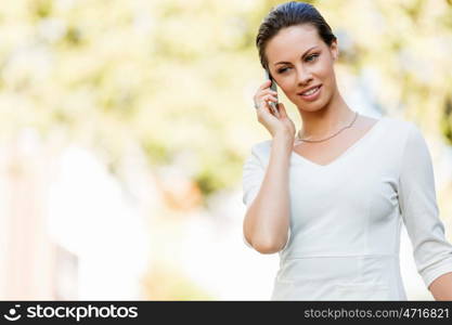 Portrait of business woman smiling outdoor. Portrait of young business woman with mobile phone outdoors