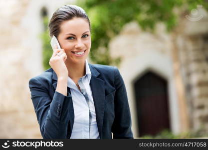 Portrait of business woman smiling outdoor. Portrait of young business woman with mobile phone outdoors