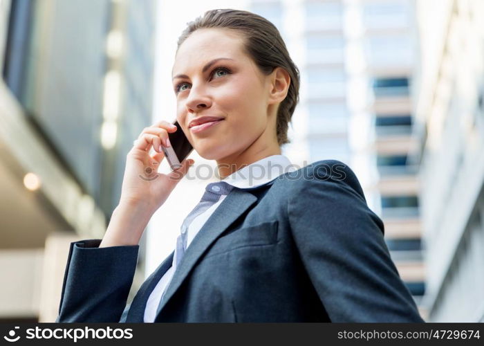 Portrait of business woman smiling outdoor. Portrait of young business woman with mobile phone outdoors