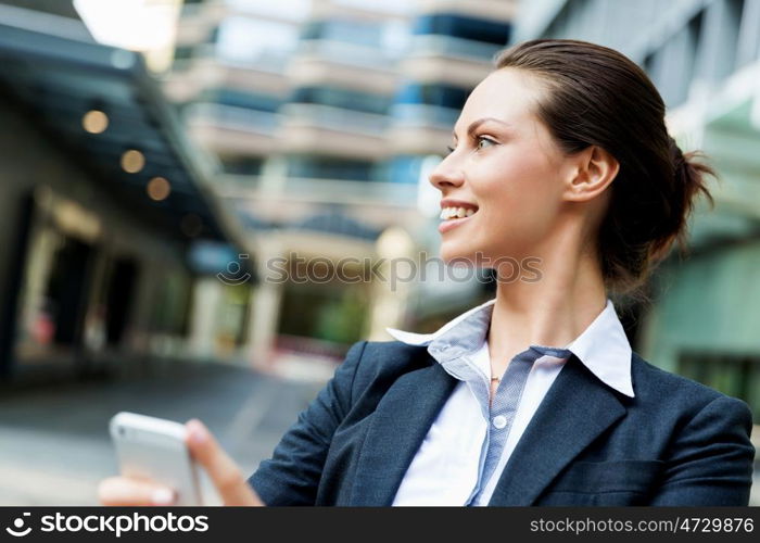 Portrait of business woman smiling outdoor. Portrait of young business woman with mobile phone outdoors