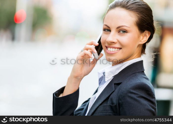 Portrait of business woman smiling outdoor. Portrait of young business woman with mobile phone outdoors