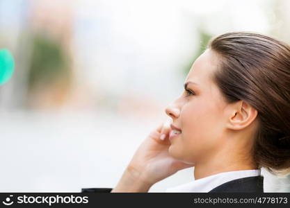 Portrait of business woman smiling outdoor. Portrait of young business woman with mobile phone outdoors