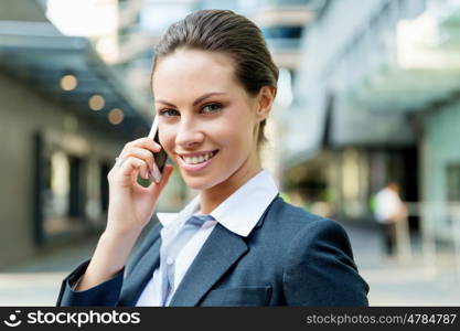 Portrait of business woman smiling outdoor. Portrait of young business woman with mobile phone outdoors