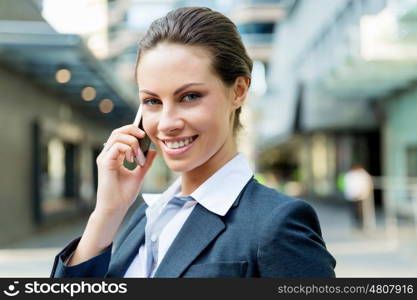 Portrait of business woman smiling outdoor. Portrait of young business woman with mobile phone outdoors