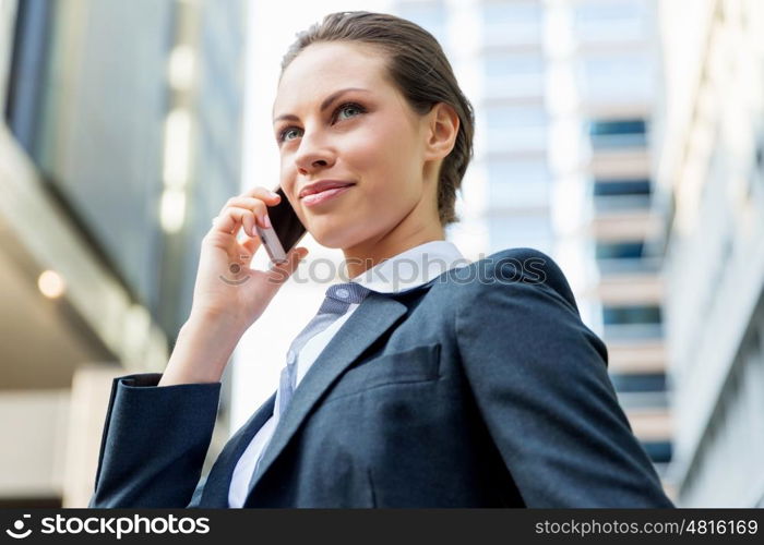 Portrait of business woman smiling outdoor. Portrait of young business woman with mobile phone outdoors