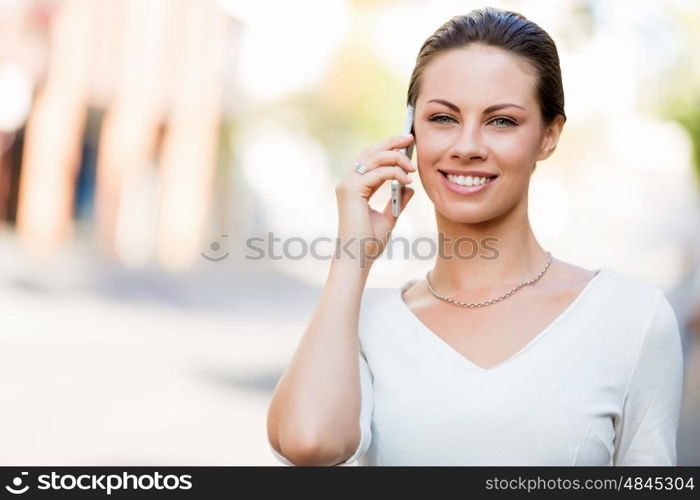 Portrait of business woman smiling outdoor. Portrait of young business woman with mobile phone outdoors