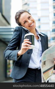 Portrait of business woman smiling outdoor. Portrait of young business woman with mobile phone outdoors