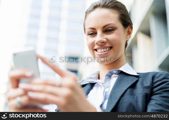 Portrait of business woman smiling outdoor. Portrait of young business woman with mobile phone outdoors