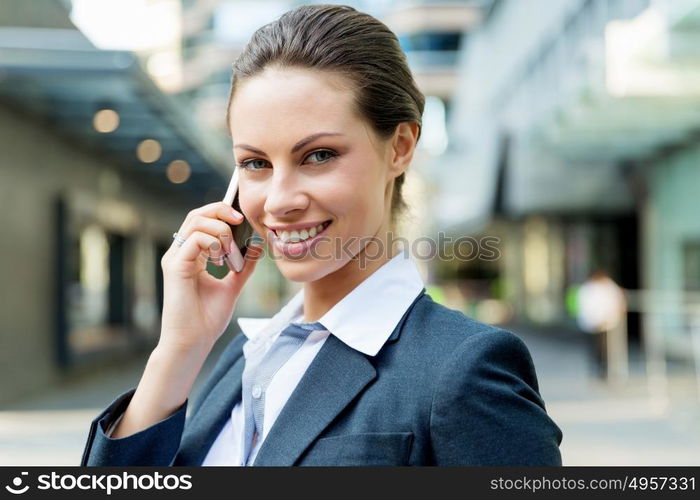 Portrait of business woman smiling outdoor. Portrait of young business woman with mobile phone outdoors