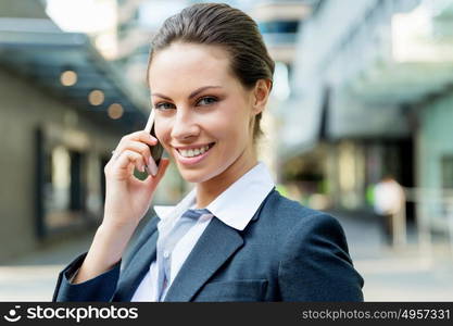 Portrait of business woman smiling outdoor. Portrait of young business woman with mobile phone outdoors