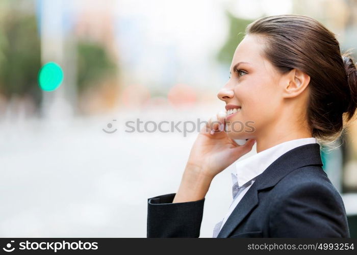 Portrait of business woman smiling outdoor. Portrait of young business woman with mobile phone outdoors