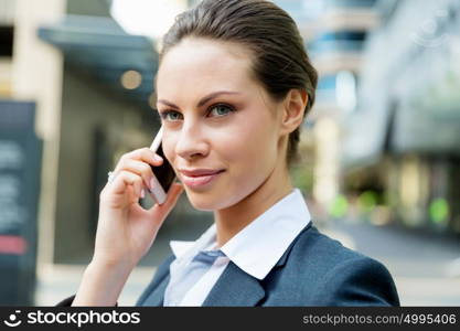 Portrait of business woman smiling outdoor. Portrait of young business woman with mobile phone outdoors