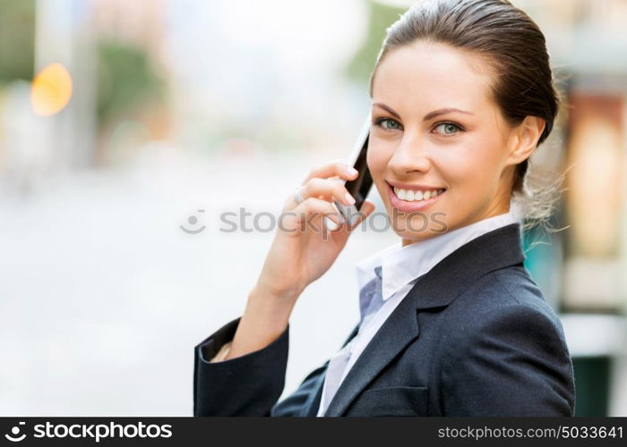 Portrait of business woman smiling outdoor. Portrait of young business woman with mobile phone outdoors