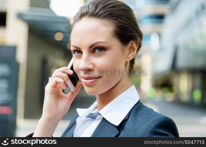 Portrait of business woman smiling outdoor. Portrait of young business woman with mobile phone outdoors