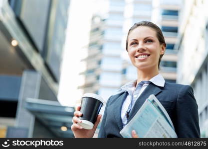 Portrait of business woman walking and smiling outdoor. Portrait of young business woman walking in city