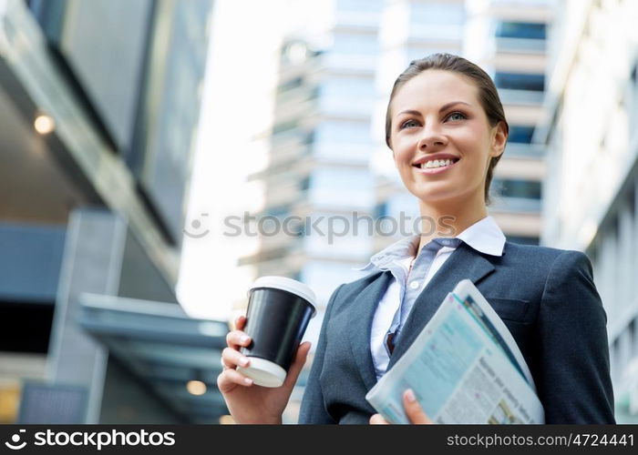 Portrait of business woman walking and smiling outdoor. Portrait of young business woman walking in city