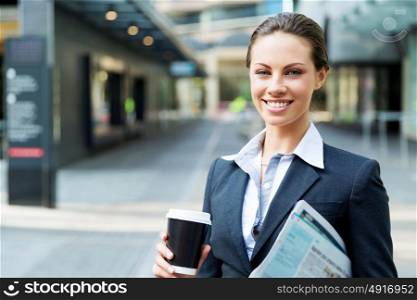 Portrait of business woman walking and smiling outdoor. Portrait of young business woman walking in city