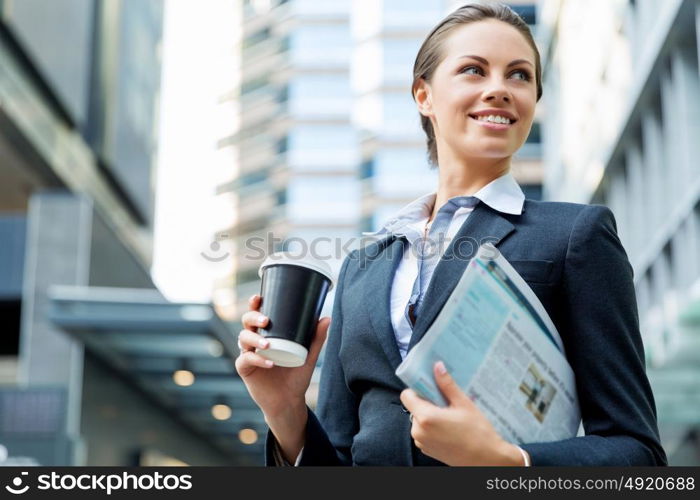 Portrait of business woman walking and smiling outdoor. Portrait of young business woman walking in city