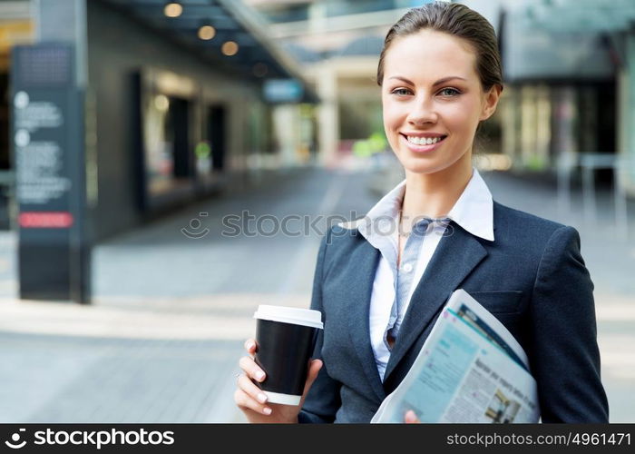 Portrait of business woman walking and smiling outdoor. Portrait of young business woman walking in city