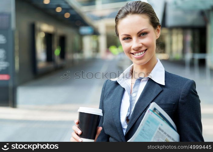 Portrait of business woman walking and smiling outdoor. Portrait of young business woman walking in city