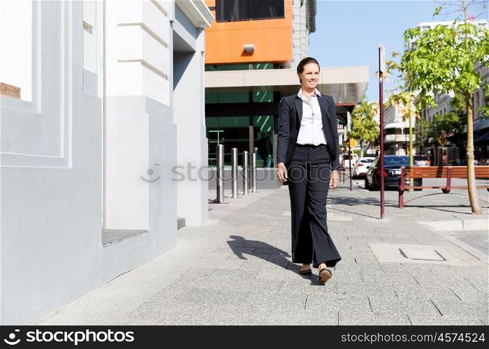 Portrait of business woman walking outdoor. Portrait of young business woman walking outdoors