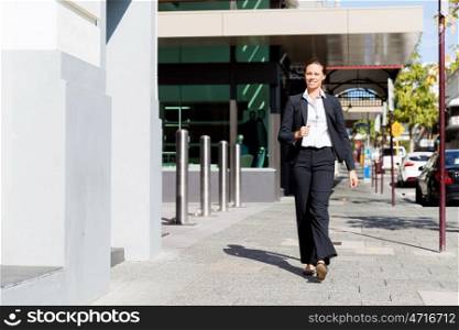 Portrait of business woman walking outdoor. Portrait of young business woman walking outdoors
