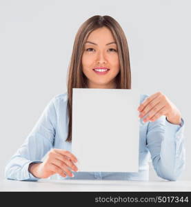 Portrait of business woman with blank sheet over gray background