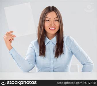 Portrait of business woman with blank sheet over gray background
