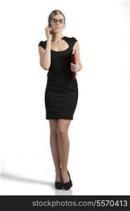 portrait of business woman with elegant sexy dress, organizer in the hands and glasses. She talking with smartphone &#xA;