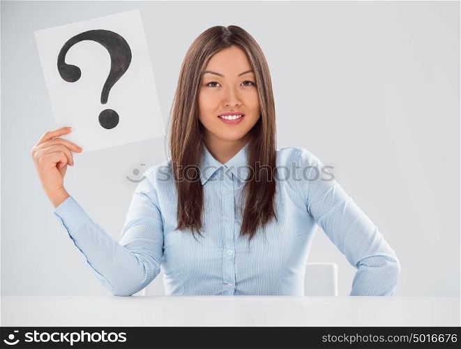 Portrait of business woman with question mark on placard over gray background