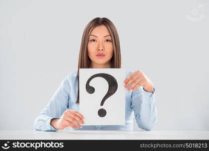 Portrait of business woman with question mark on placard over gray background