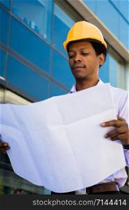 Portrait of Businessman engineer developer holding blueprint working outdoors.