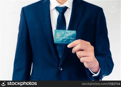 Portrait of businessman holding a credit card showing front view to the camera in close up view. Online shopping business and cashless payment concept.. Portrait of a businessman holding a credit card.