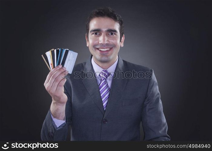 Portrait of businessman holding credit cards