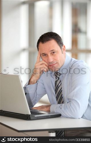 Portrait of businessman in front of laptop computer