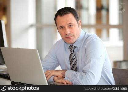 Portrait of businessman in front of laptop computer