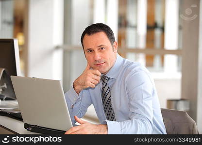 Portrait of businessman in front of laptop computer