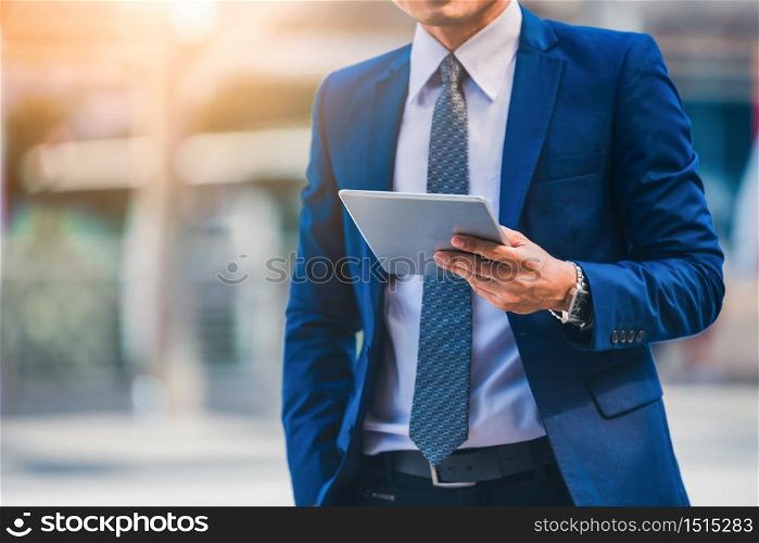 Portrait of businessman looking digital tablet on blurred background. Business success concept.